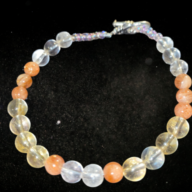 Collier fait de perles translucides et colorées, avec un fermoir en métal.