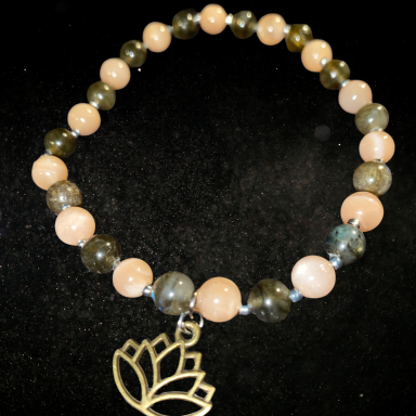 Bracelet en perles avec pendant en forme de lotus. Perles variées de teintes douces.