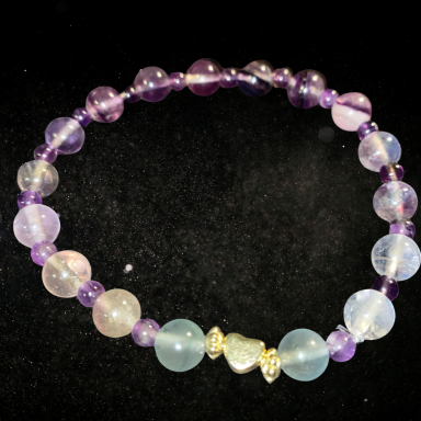 Bracelet en perles multicolores avec des nuances de violet et de bleu.